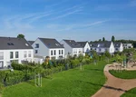 Moderne Wohnsiedlung mit energieeffizienten Einfamilienhäusern und großzügigen Grünflächen als Beispiel für nachhaltige Quartierskonzepte der RegioEnergie.