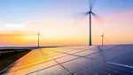 Weitwinkel-Panoramaaufnahme eines Hybrid-Kraftwerks mit weitläufigen Photovoltaikanlagen im Vordergrund und mehreren Windkraftanlagen am Horizont bei Sonnenuntergang.